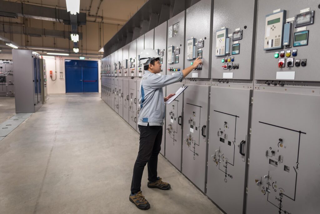 Engineer working and check status switchgear electrical energy distribution at substation room